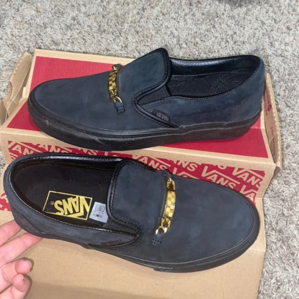 Black vans with gold pendant across it
